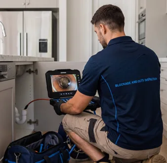 Plumber clearing a blocked toilet in a Randwick bathroom